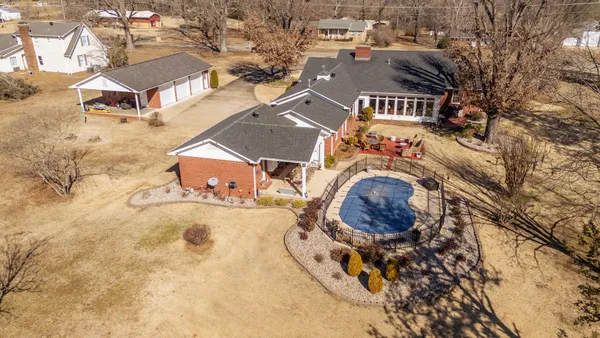 an aerial view of residential houses with outdoor space and parking