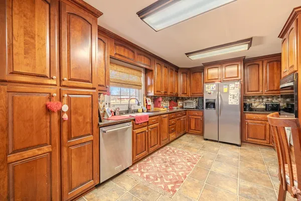 a kitchen with stainless steel appliances granite countertop a refrigerator sink and cabinets