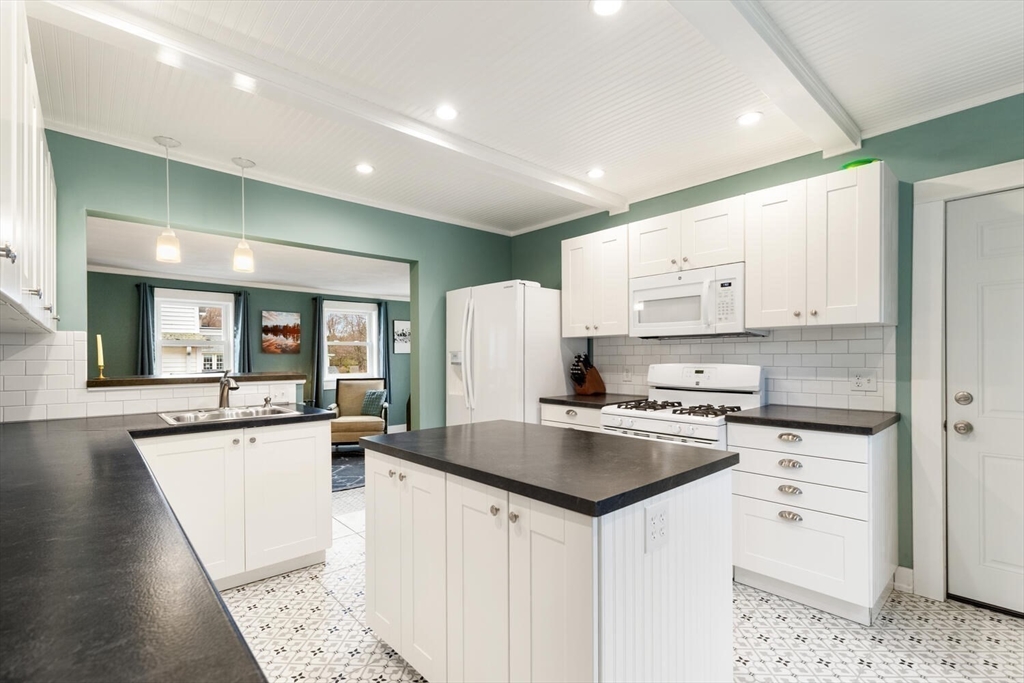 687 Main Street Wakefield, MA 01880 - Photo 16 of 36 a kitchen with stainless steel appliances a stove a sink a refrigerator white cabinets and wooden floor