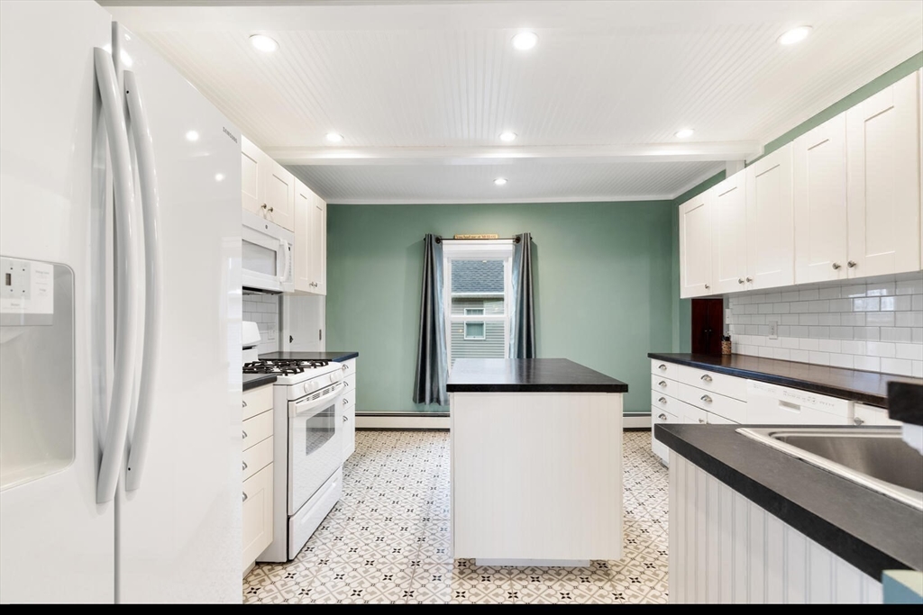687 Main Street Wakefield, MA 01880 - Photo 17 of 36 a kitchen with stainless steel appliances granite countertop a sink stove and refrigerator