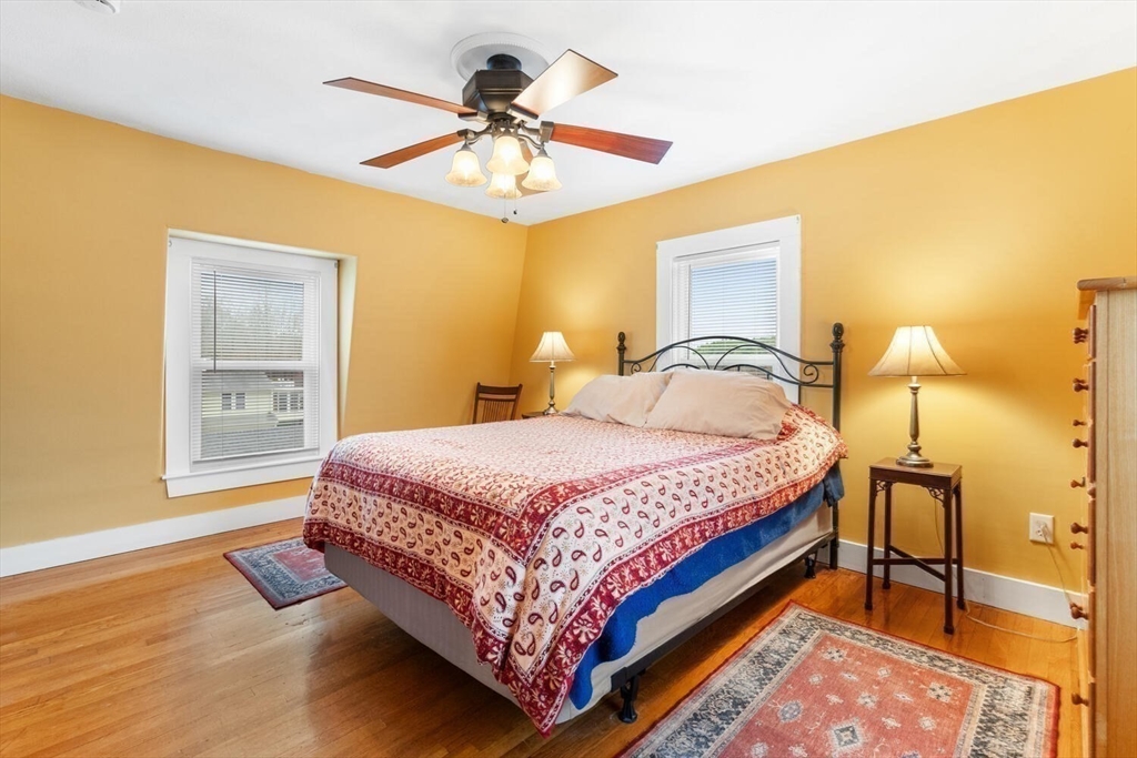 687 Main Street Wakefield, MA 01880 - Photo 25 of 36 a bedroom with a bed and wooden floor
