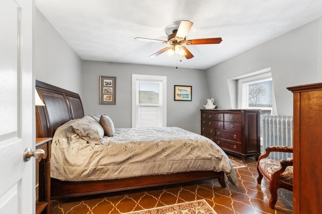 687 Main Street Wakefield, MA 01880 - Photo 27 of 36 a bedroom with a bed and dresser with mirror