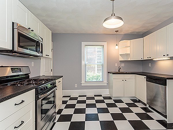 687 Main Street Wakefield, MA 01880 - Photo 6 of 36 a kitchen with stainless steel appliances a stove a microwave and cabinets