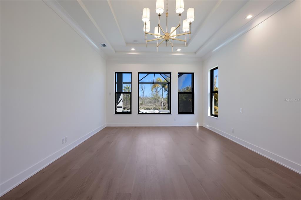 1107 Blue Shell Loop Sarasota, FL 34240 - Photo 25 of 88 an empty room with wooden floor chandelier and windows
