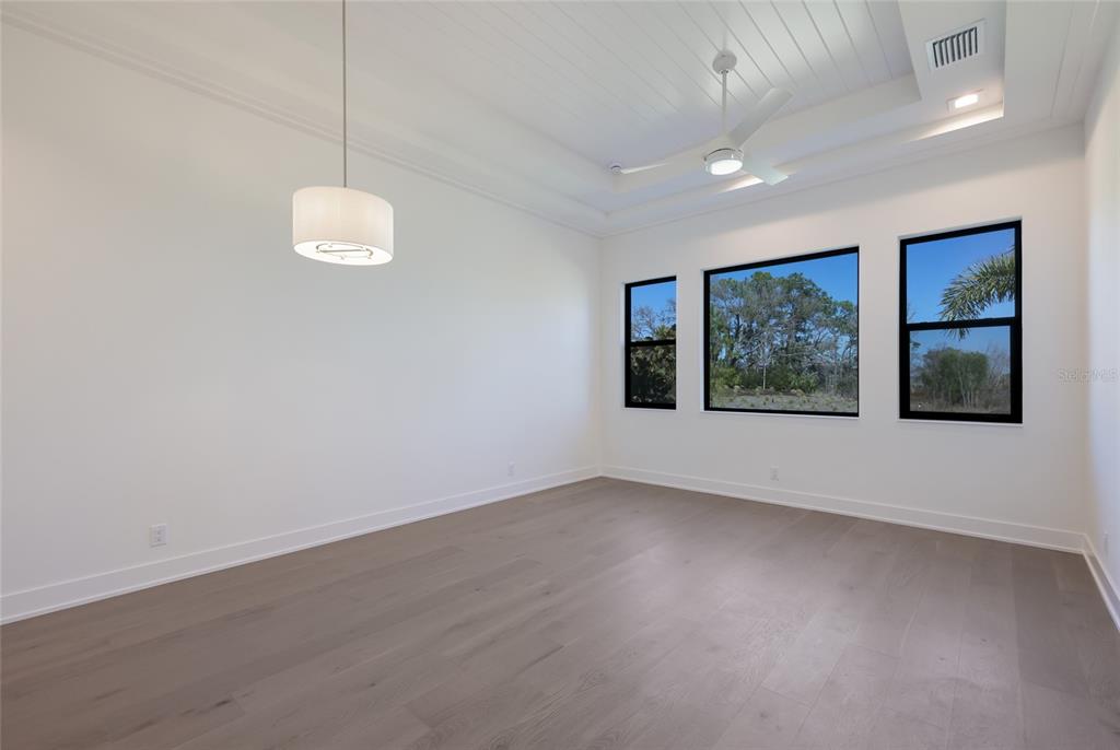 1107 Blue Shell Loop Sarasota, FL 34240 - Photo 36 of 88 an empty room with wooden floor and windows