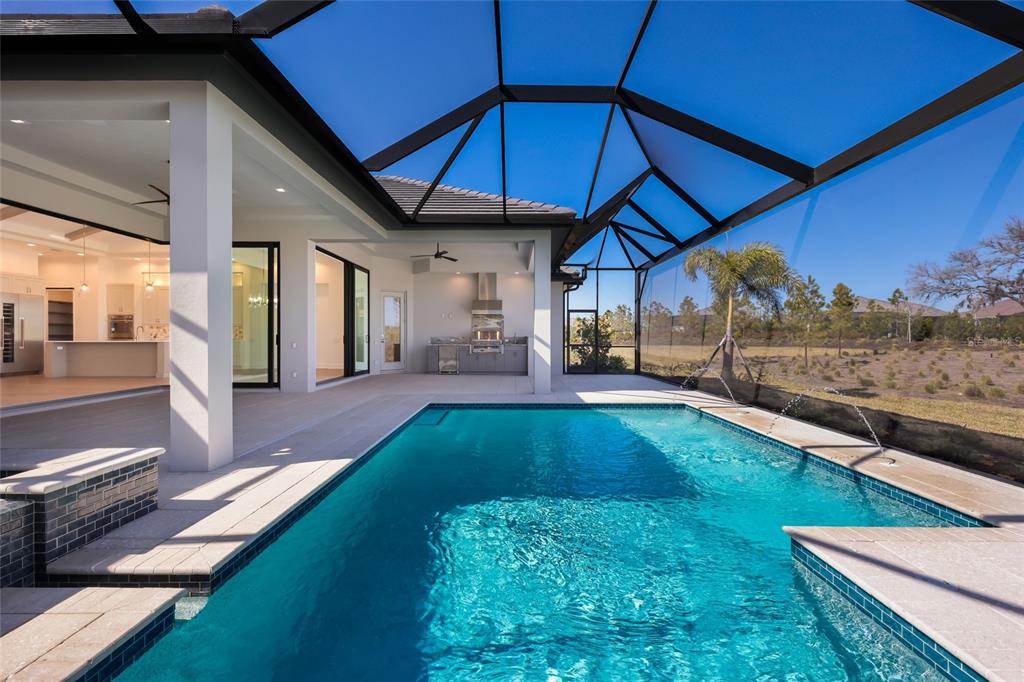 1107 Blue Shell Loop Sarasota, FL 34240 - Photo 50 of 88 a view of a backyard with lawn chairs under an umbrella