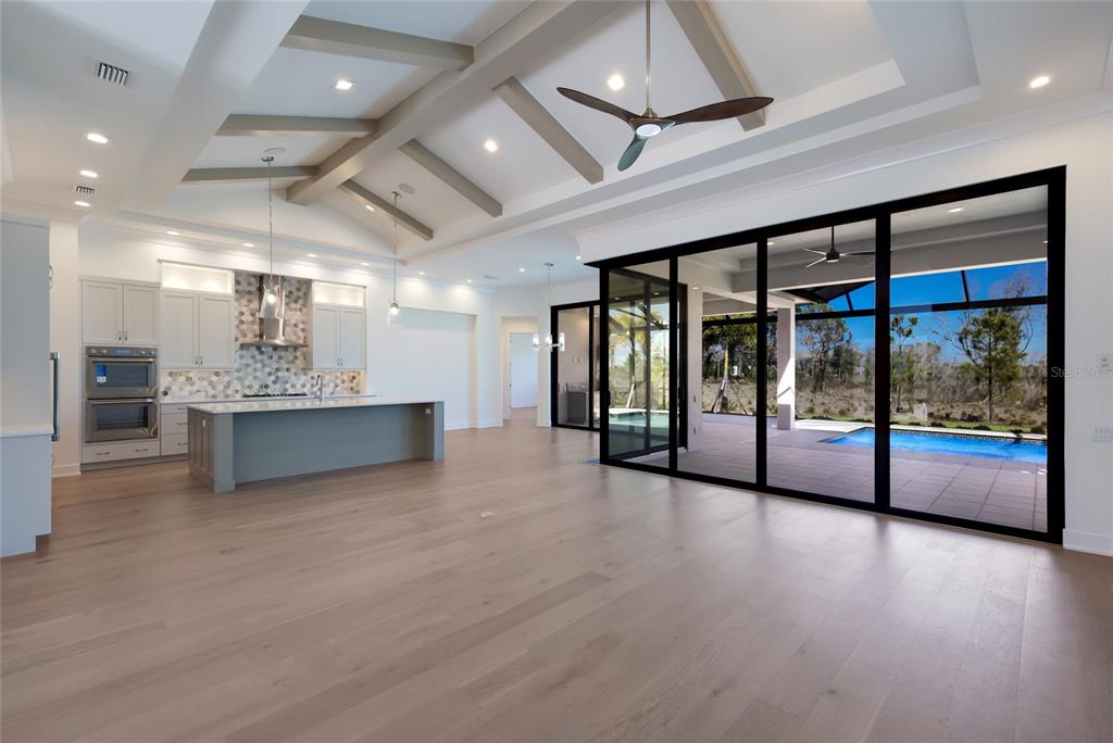 1107 Blue Shell Loop Sarasota, FL 34240 - Photo 6 of 88 a view of an empty room with window and wooden floor