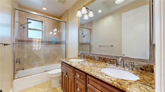 a bathroom with a granite countertop sink a large mirror and a shower
