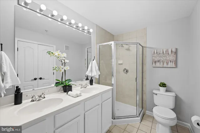a bathroom with a shower sink vanity mirror and toilet