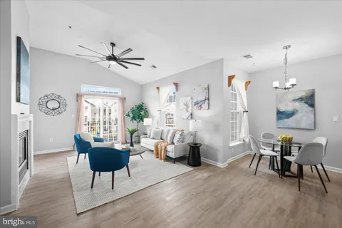 a living room with furniture a window and wooden floor