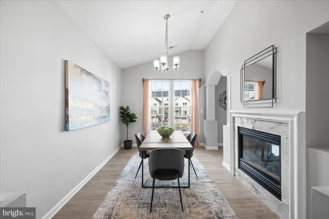 a dining room with furniture a fireplace and wooden floor