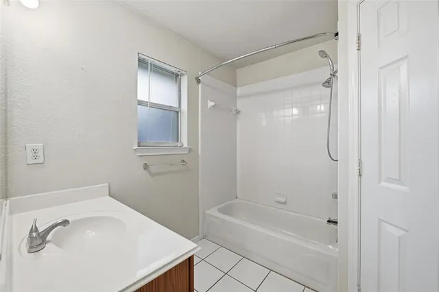 a bathroom with a tub shower vanity and a sink