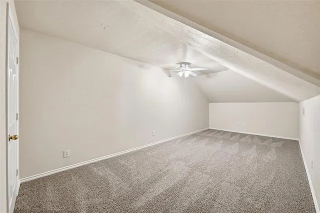 an empty room with fireplace fan and windows