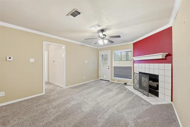 a view of an empty room with kitchen and a window