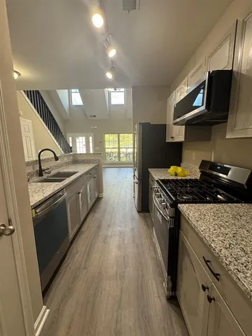 a large kitchen with stainless steel appliances granite countertop a stove and a sink