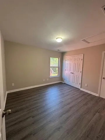 an empty room with wooden floor and window