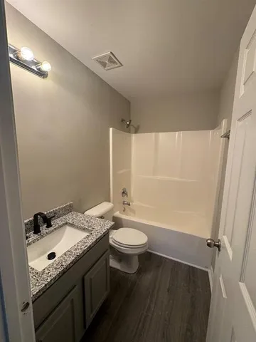 a bathroom with a granite countertop sink toilet a mirror and shower