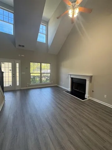 an empty room with wooden floor chandelier and glass door