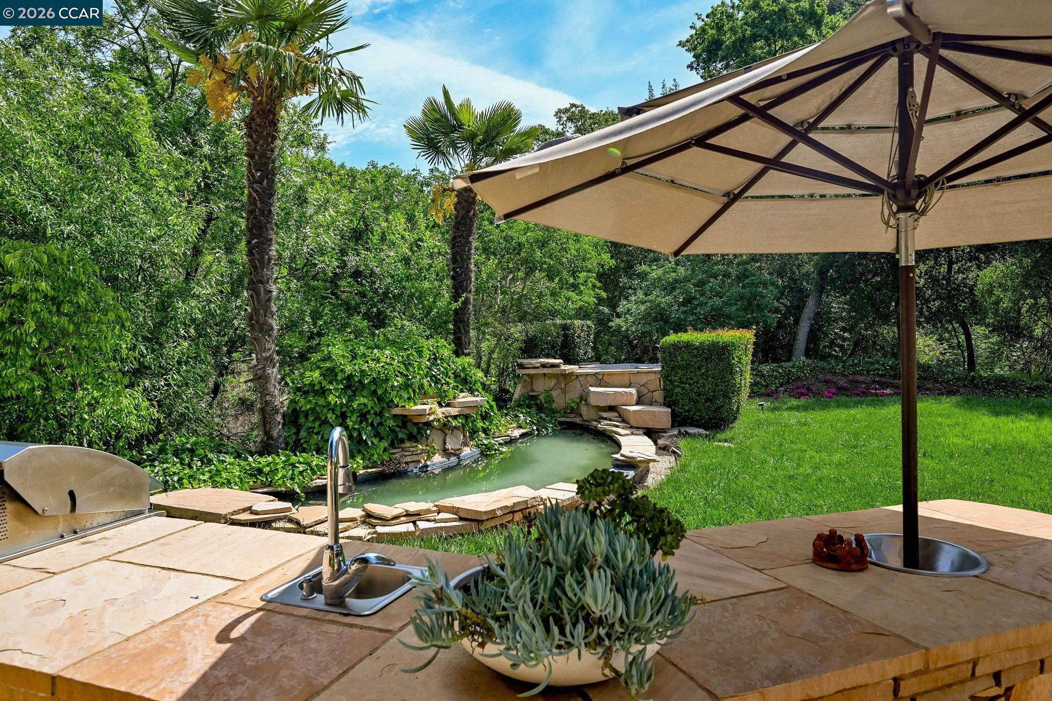 490 St Marys Road Lafayette, CA 94549 - Photo 31 of 61 a backyard of a house with table and chairs under an umbrella