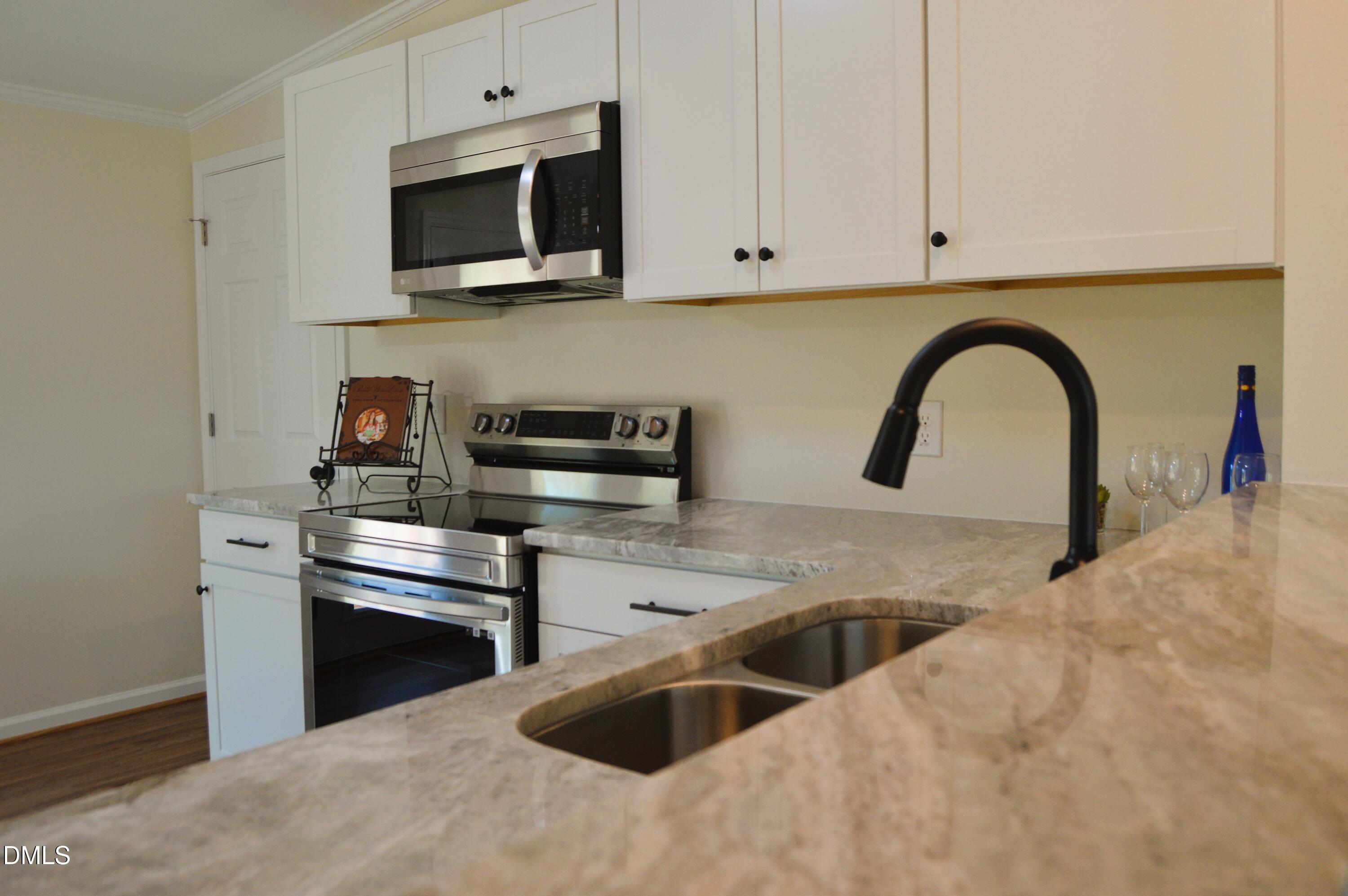 1159 No Bottom Road Warrenton, NC 27589 - Photo 11 of 43 a kitchen with stainless steel appliances granite countertop a sink a microwave and stove