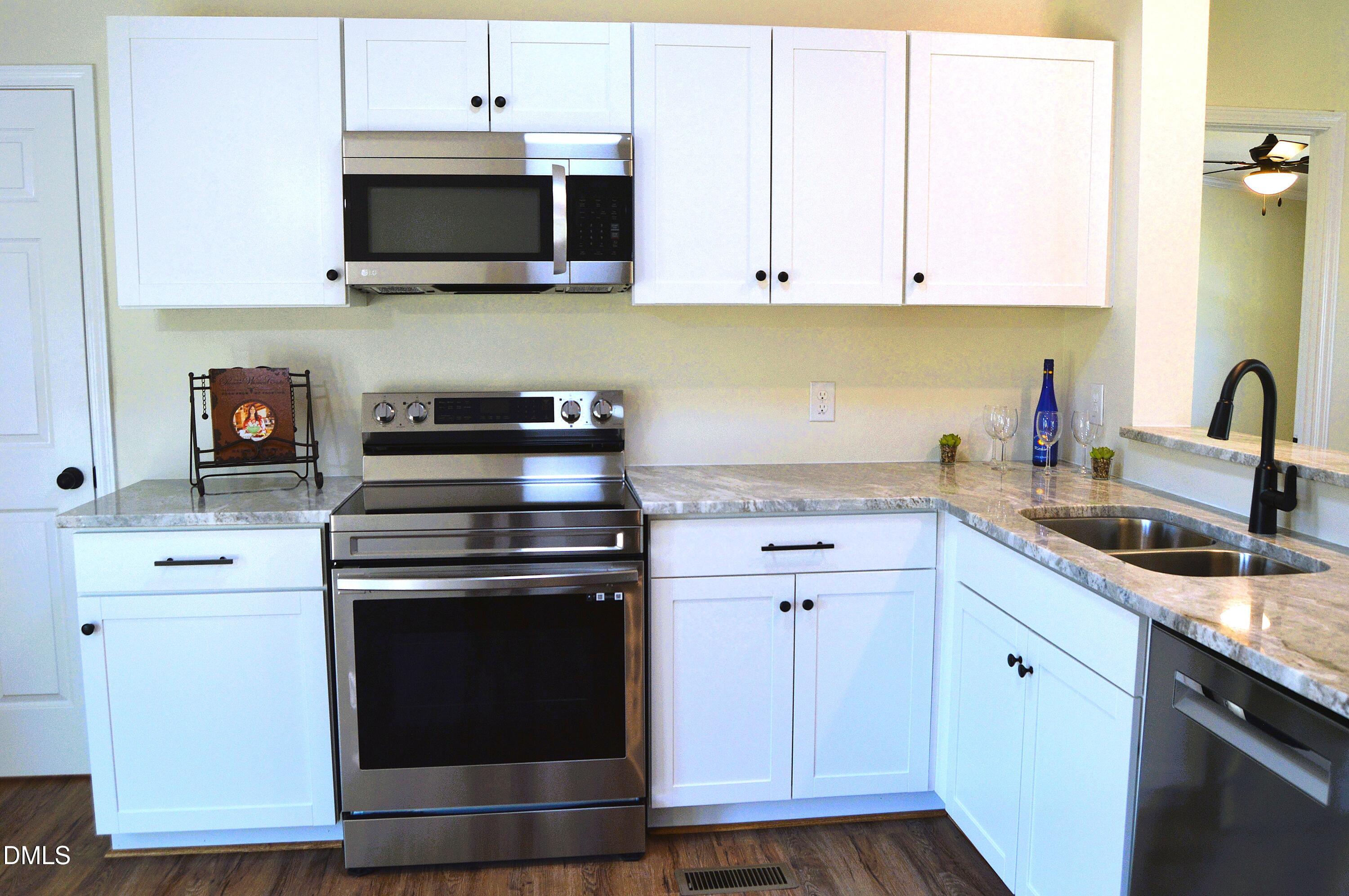 1159 No Bottom Road Warrenton, NC 27589 - Photo 13 of 43 a kitchen with stainless steel appliances granite countertop a stove a sink and a microwave