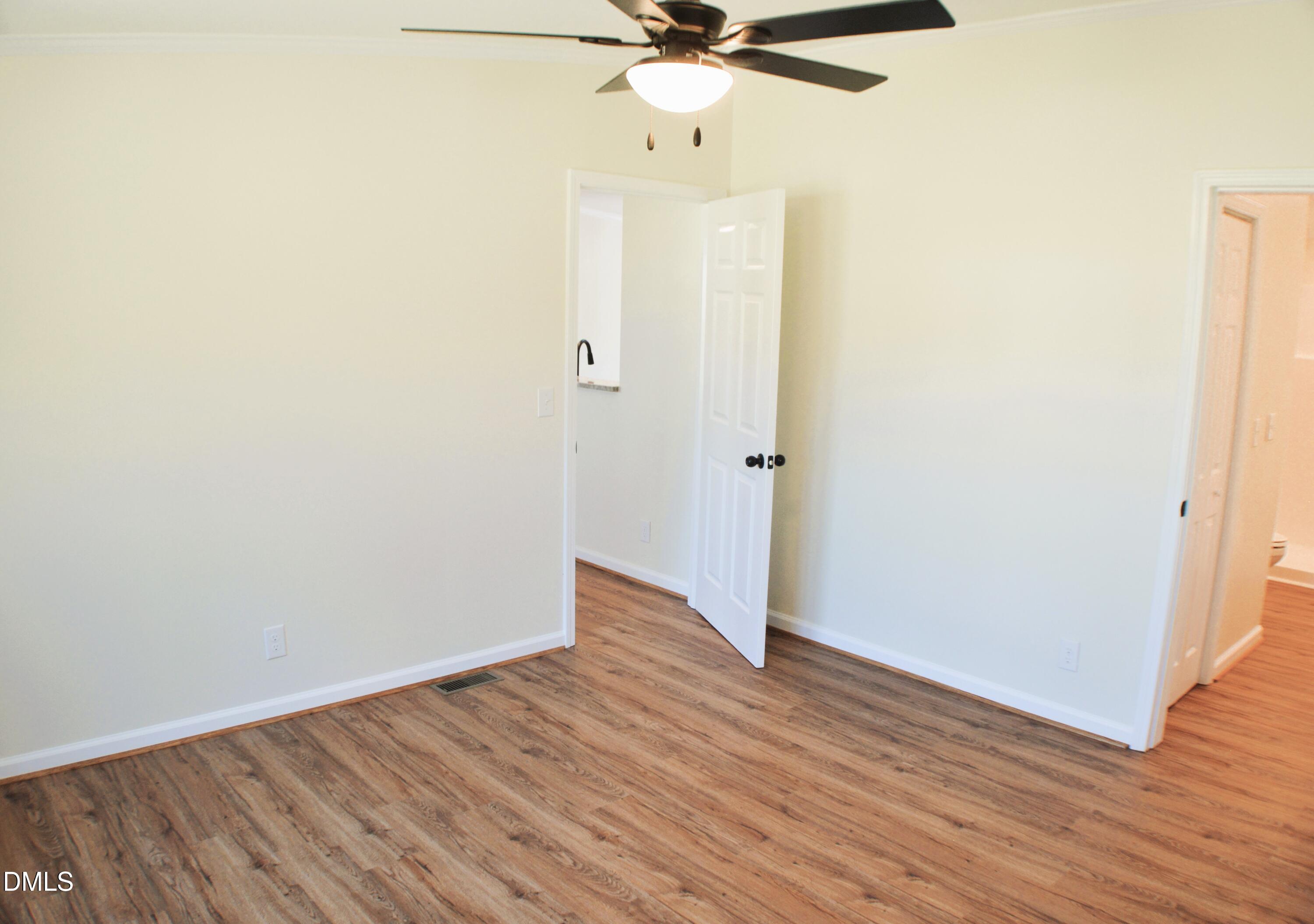 1159 No Bottom Road Warrenton, NC 27589 - Photo 29 of 43 an empty room with wooden floor fan and windows