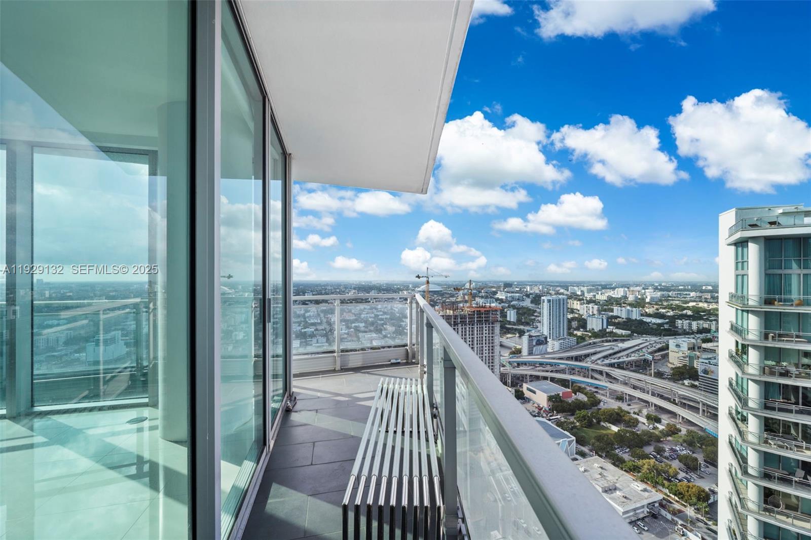 92 Southwest 3rd Street, Unit 4610 Miami, FL 33130 - Photo 14 of 16 a view of a balcony with a floor to ceiling window wooden stairs and a glass door