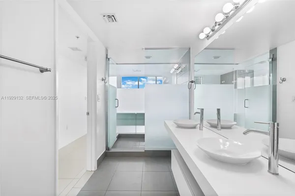 a bathroom with a double vanity sink mirror and shower