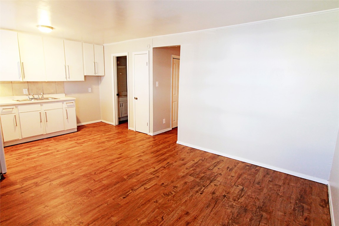 901 Springdale Road, Unit 102 Austin, TX 78702 - Photo 5 of 17 Kitchen with light wood-type flooring, white cabinets, and light countertops
