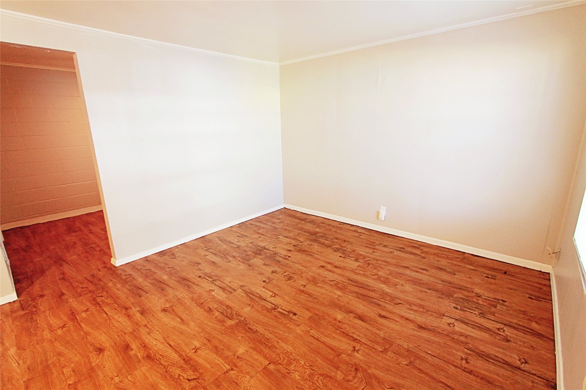 901 Springdale Road, Unit 102 Austin, TX 78702 - Photo 8 of 17 Empty room with crown molding and wood finished floors