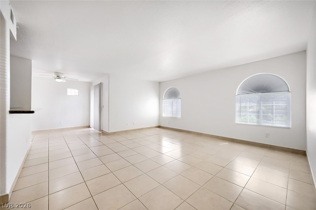 9325 West Desert Inn Road, Unit 177 Las Vegas, NV 89117 - Photo 5 of 24 Ceramic tile flooring extends through this airy living space, illuminated by arched windows.