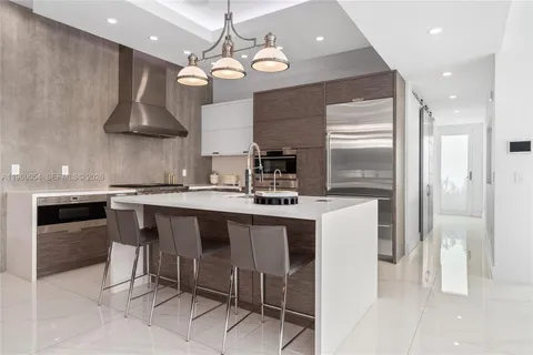 a kitchen with stainless steel appliances a table and chairs in it