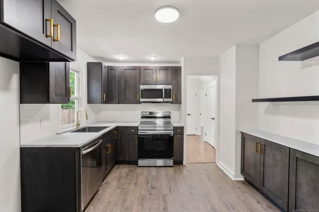 a kitchen with stainless steel appliances granite countertop a sink stove and refrigerator