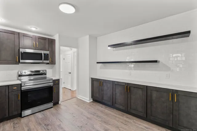 a kitchen with stainless steel appliances a stove microwave and refrigerator