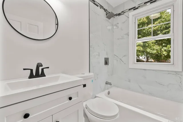 a bathroom with a sink a toilet and a mirror