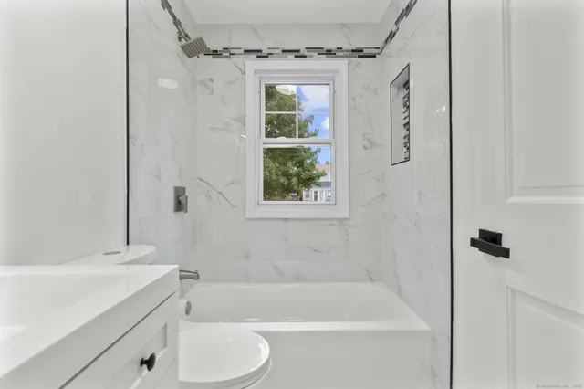 a bathroom with a shower toilet and bathtub