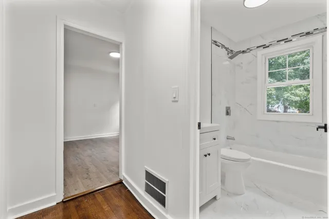 a bathroom with a tub a toilet and a shower