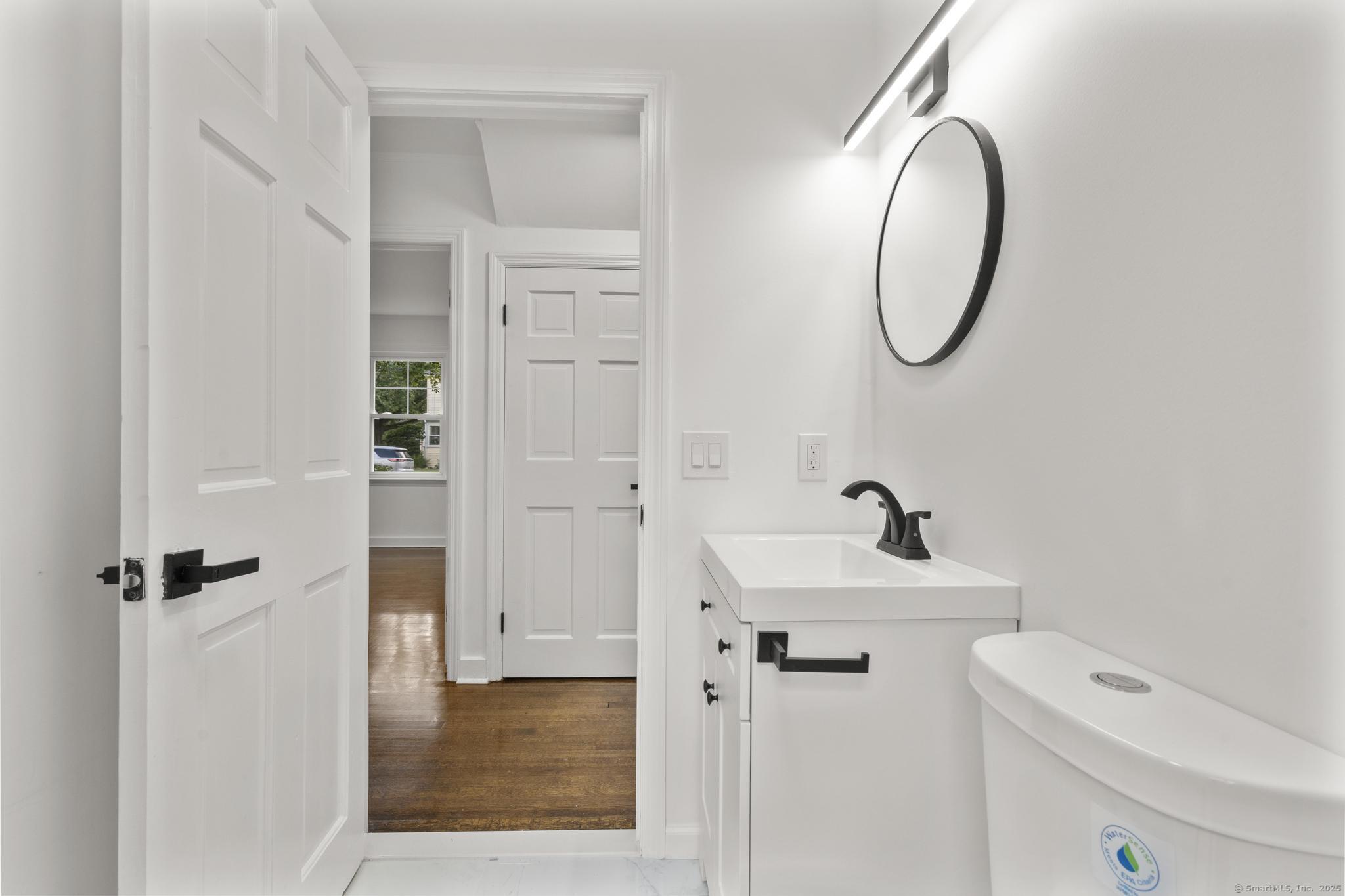 203 Gorham Avenue Hamden, CT 06514 - Photo 18 of 31 a bathroom with a sink a toilet and a mirror