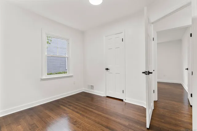 an empty room with wooden floor and a window