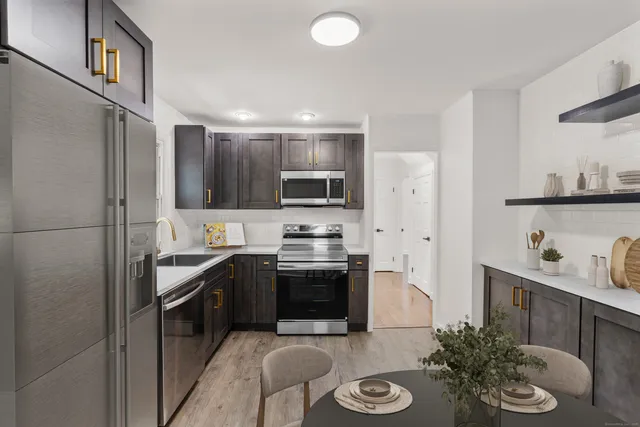 a kitchen with stainless steel appliances granite countertop a sink stove and refrigerator