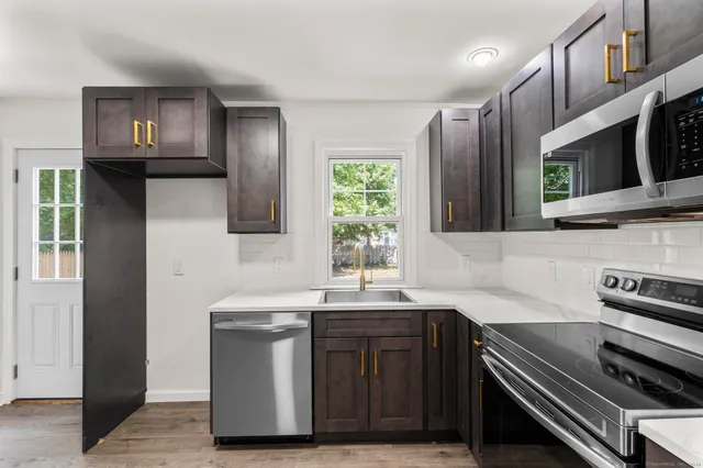 a kitchen with stainless steel appliances a sink a stove a microwave and cabinets