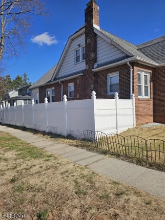 a view of a house with a wooden fence