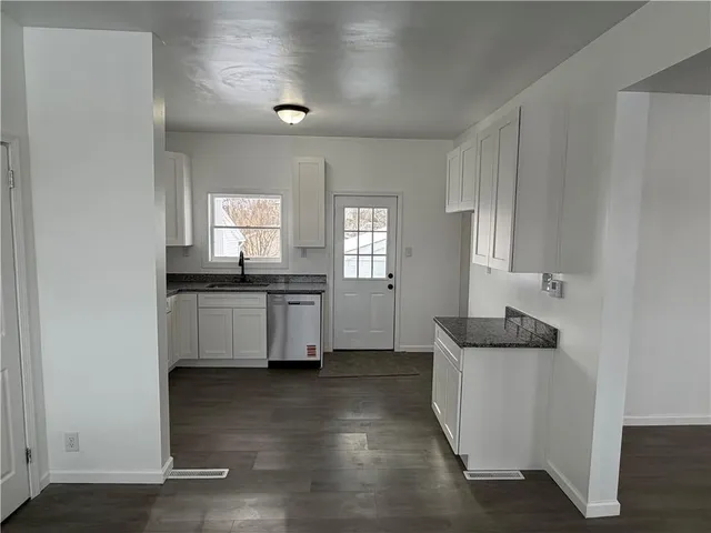 a kitchen with white cabinets and white appliances