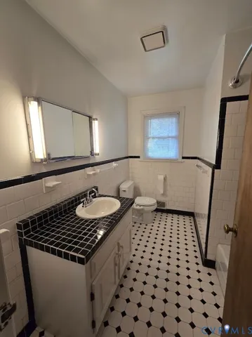 a bathroom with a sink a toilet a mirror and shower