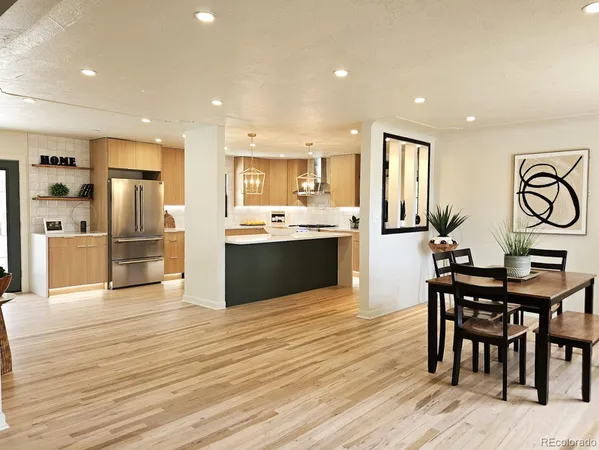a kitchen with stainless steel appliances kitchen island granite countertop a table and chairs in it