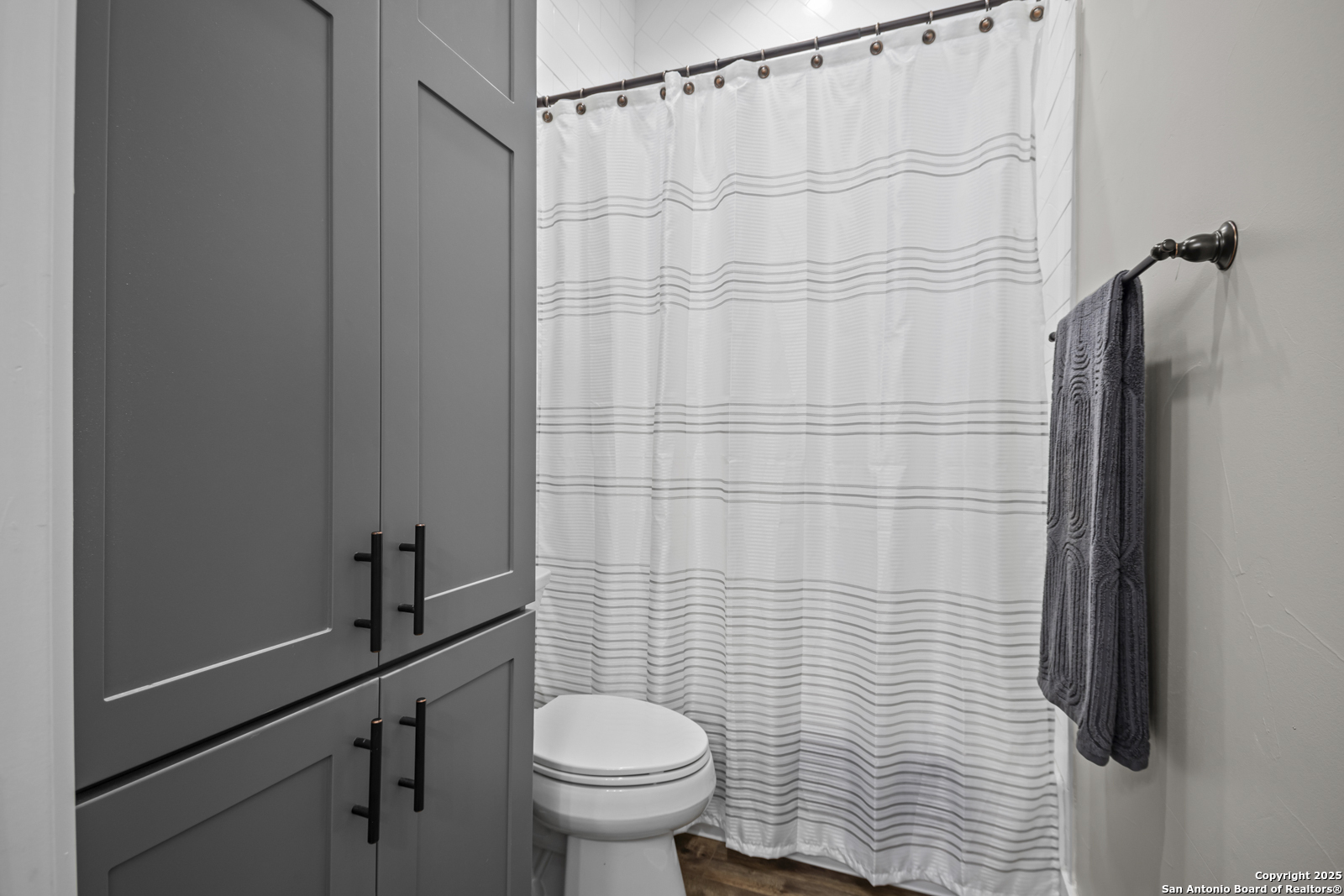 209 River Ridge Boerne, TX 78006 - Photo 30 of 60 a bathroom with a toilet and a shower curtain