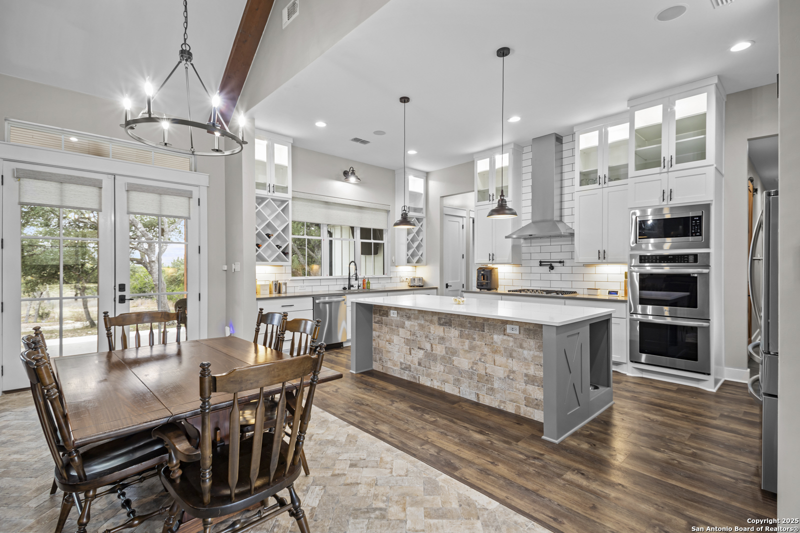 209 River Ridge Boerne, TX 78006 - Photo 7 of 60 a kitchen with stainless steel appliances kitchen island granite countertop a table chairs sink and cabinets