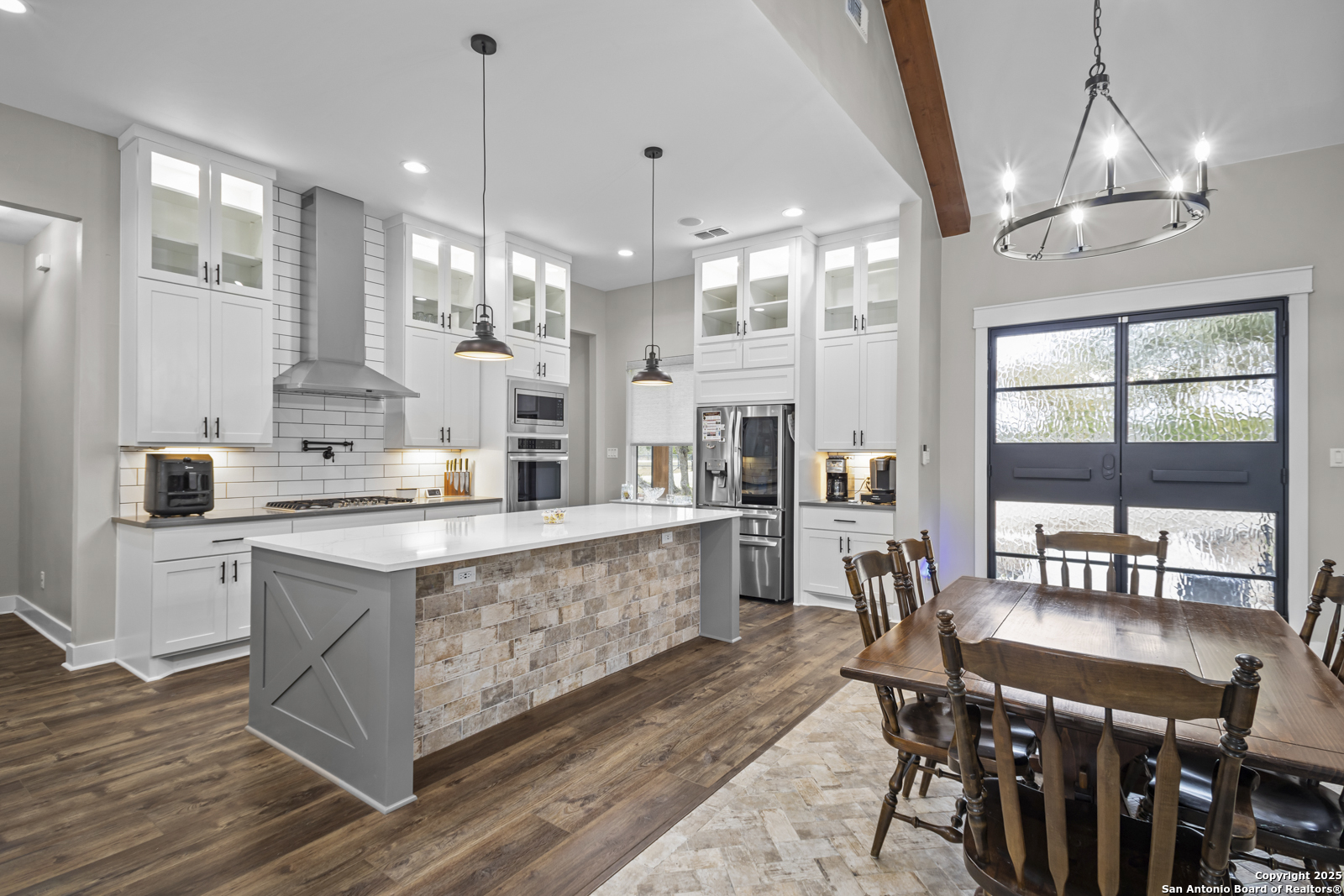 209 River Ridge Boerne, TX 78006 - Photo 9 of 60 a large white kitchen with lots of counter space and chandelier