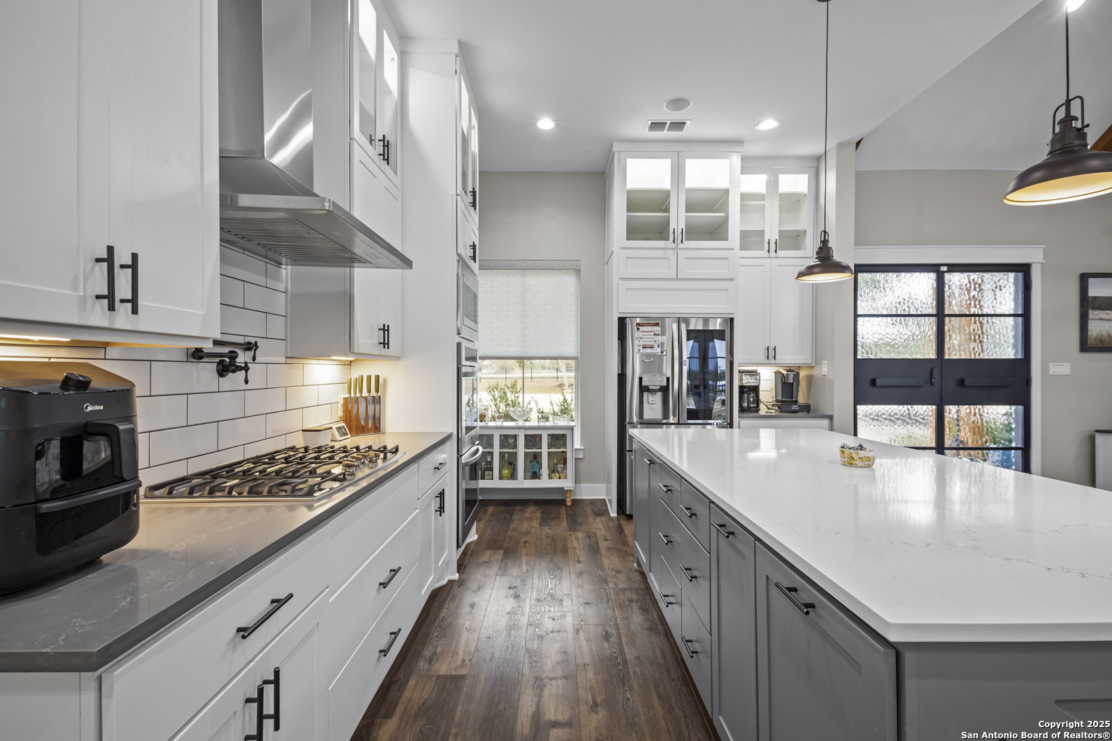 209 River Ridge Boerne, TX 78006 - Photo 10 of 60 a large kitchen with stainless steel appliances kitchen island granite countertop a large stove a sink dishwasher and cabinets with wooden floor