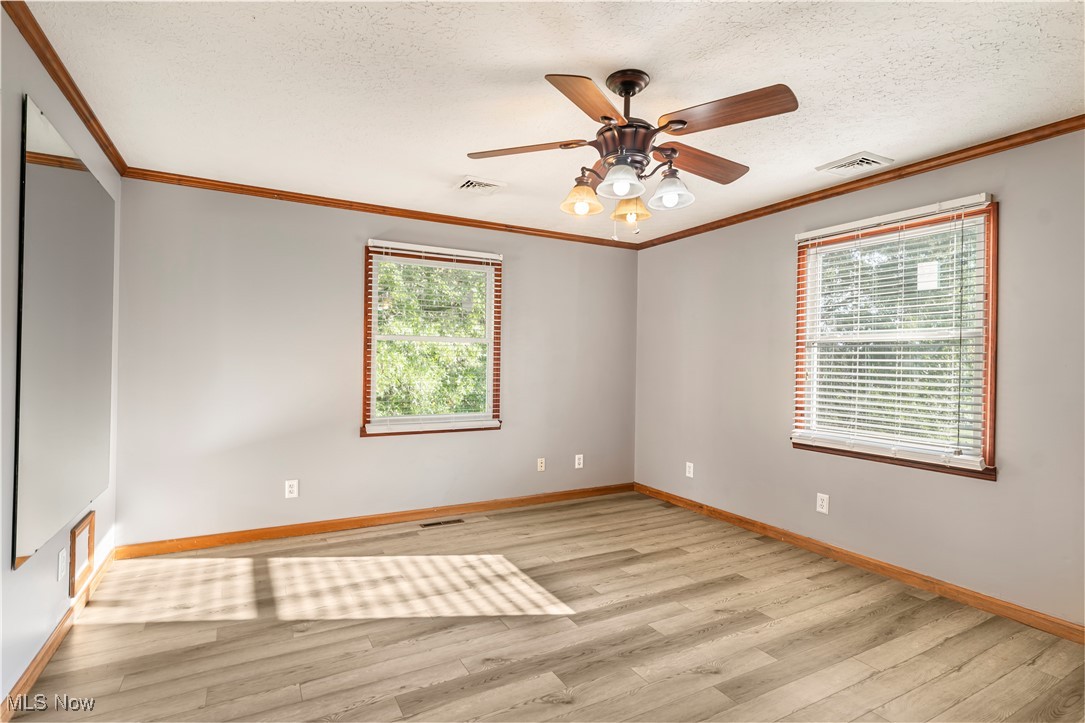 155 Ridgewood Boulevard Belpre, OH 45714 - Photo 45 of 49 Empty room featuring ornamental molding, light wood-style floors, a textured ceiling, and ceiling fan